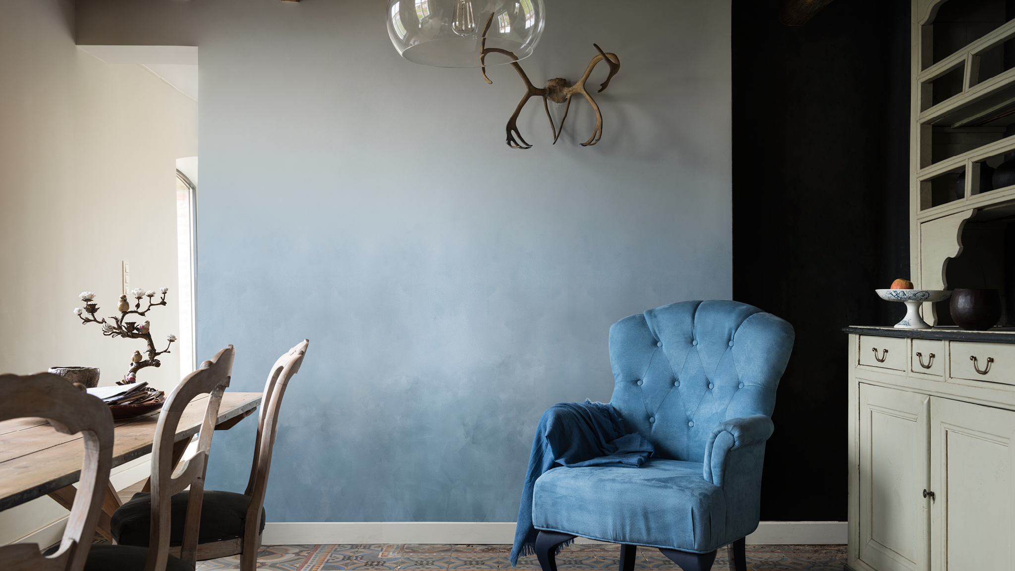 Pièce et fauteuil en bleu délavé Créez un mur en dégradé d'une même couleur, en partant d'une base foncée qui s'estompe dans des tons clairs.