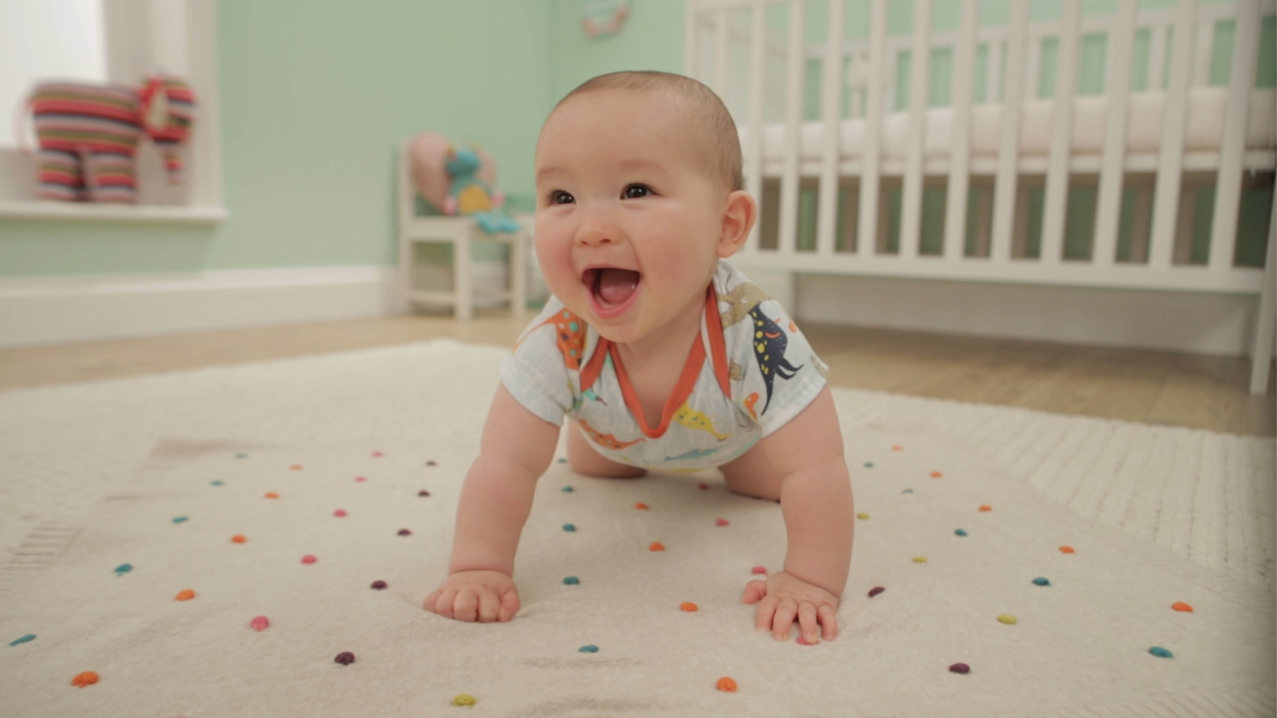 Un bébé heureux dans sa chambre Choisissez un tapis antitache confortable et assorti à la couleur de vos murs et disposez quelques coussins de sol.