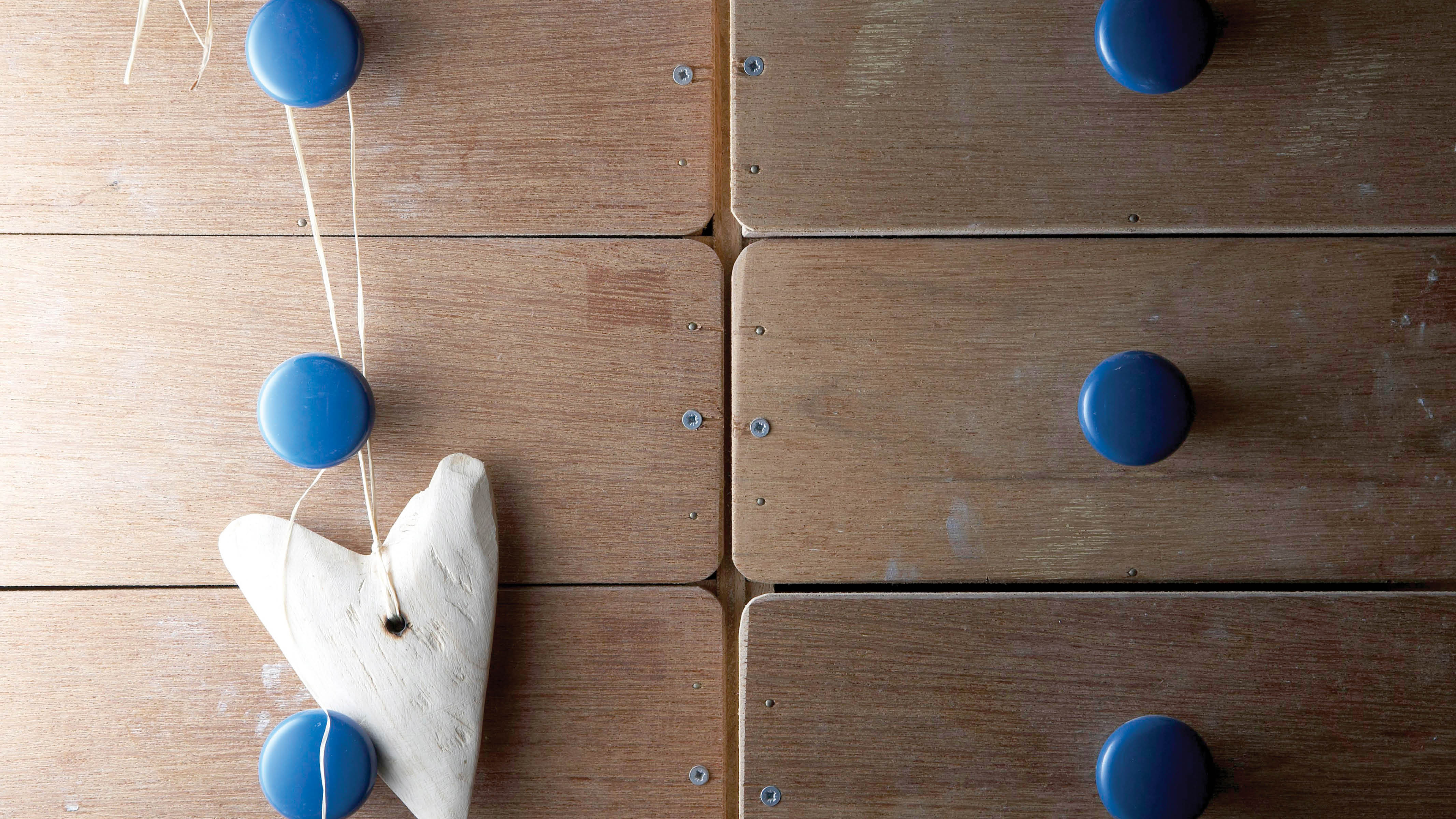 Une commode en bois avec des poignées bleues Parcourez les marchés aux puces à la recherche de jolies poignées en céramique abordables et assorties à la couleur de vos murs.