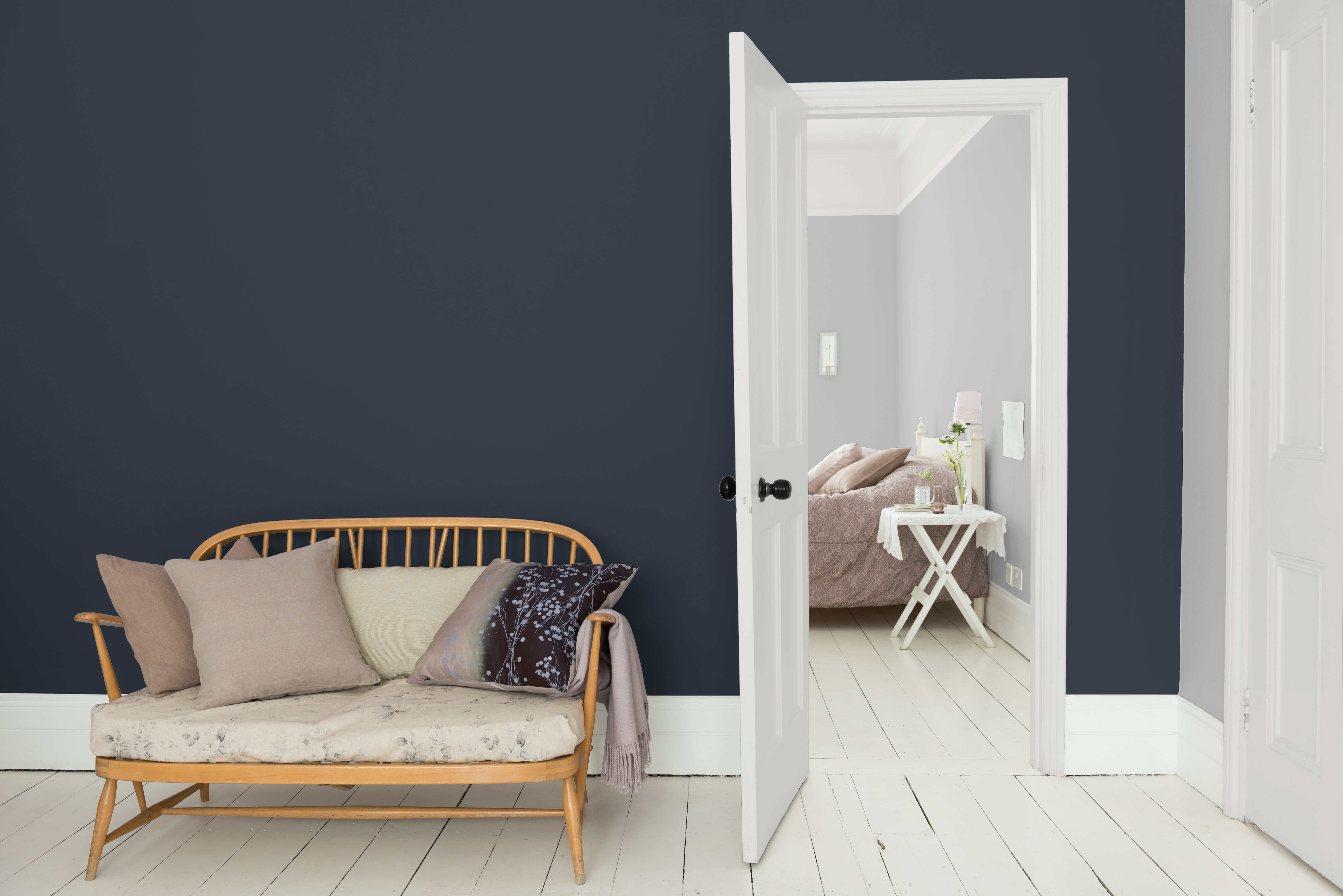 Canapé en bois avec coussins contre un mur bleu foncé/violet Dulux_Valentine_Si_Simple_idees_mur_accent_FR_4